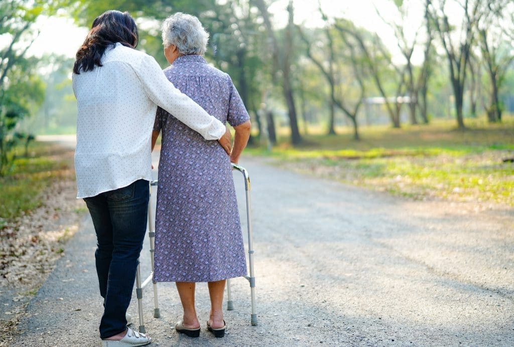 Dame âgée se faisant aide par une aide-soignante