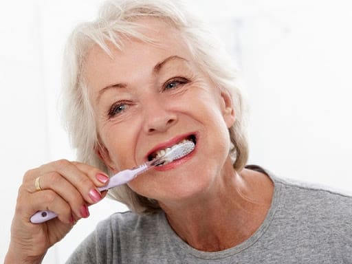 Dame âgée brossant ses dents